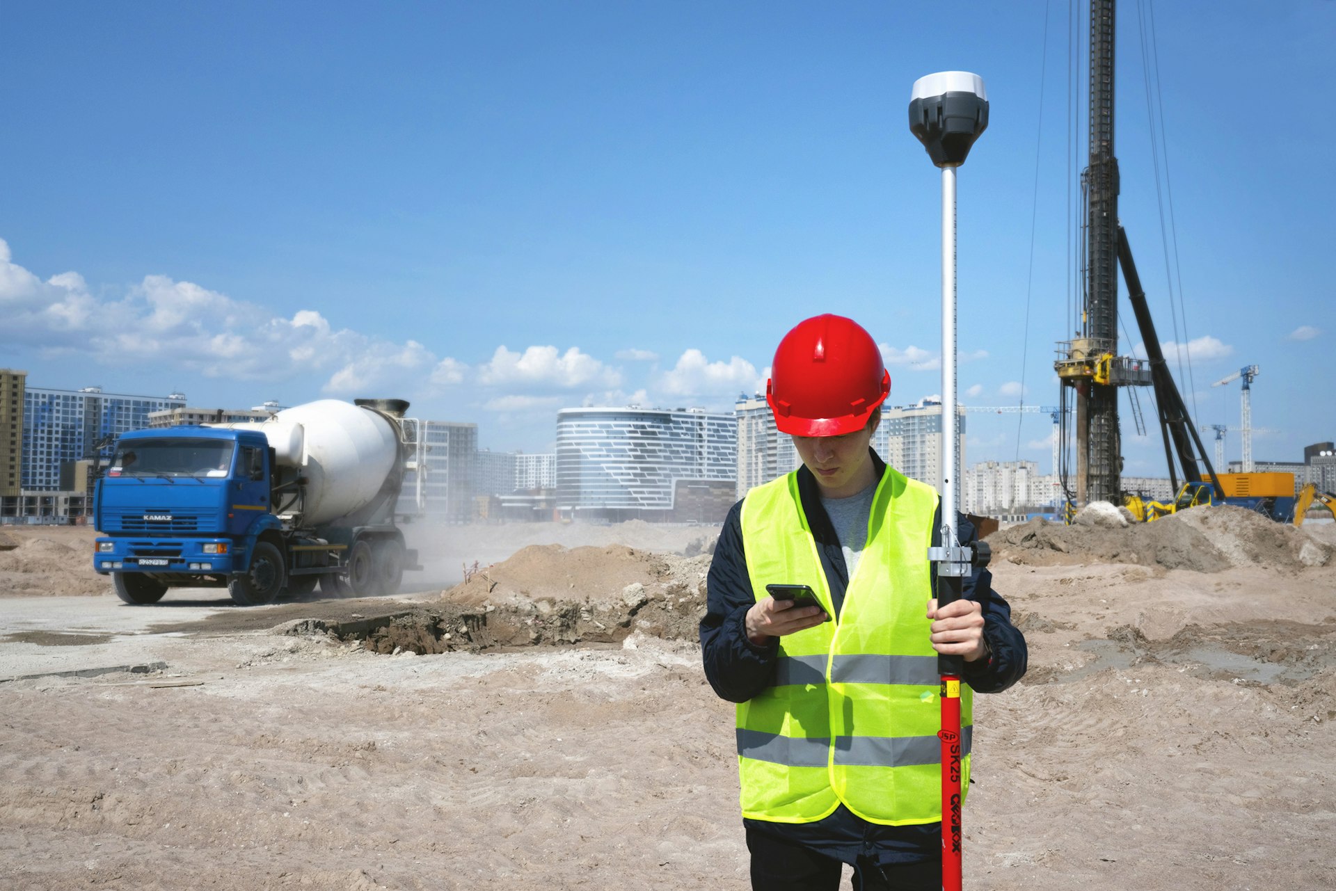 Géomètre sur un chantier, équipé d'un GPS de terrain